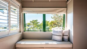 A window seat with a view of trees and a distant landscape.