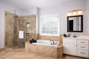 Un baño moderno con ducha de vidrio, una bañera independiente y un tocador con espejo.