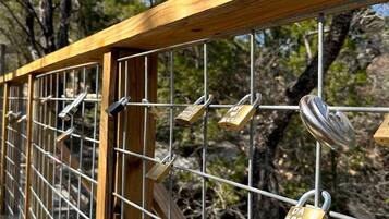 A wooden bridge with metal railings and multiple padlocks.
