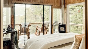 A cozy bedroom with a large bed, wooden ceiling, and a view of the outdoors. - Stunning Pet-Friendly Treehouse for Relaxing Glamping Retreats in North Carolina (Cantón)