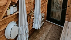 A wooden cabin with a wooden exterior, a black door, and a window. - Stunning Pet-Friendly Treehouse for Relaxing Glamping Retreats in North Carolina (Cantón)