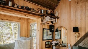 A cozy cabin interior with a bed, a window seat, a small table, and wooden walls. - Stunning Pet-Friendly Treehouse for Relaxing Glamping Retreats in North Carolina (Cantón)