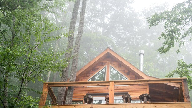 A cabin with a wooden deck, a triangular roof, and a chimney. - Stunning Pet-Friendly Treehouse for Relaxing Glamping Retreats in North Carolina (Cantón)