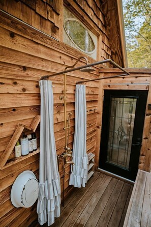 Eine Holzhütte mit Holzfassade, einer schwarzen Tür und einem Fenster.