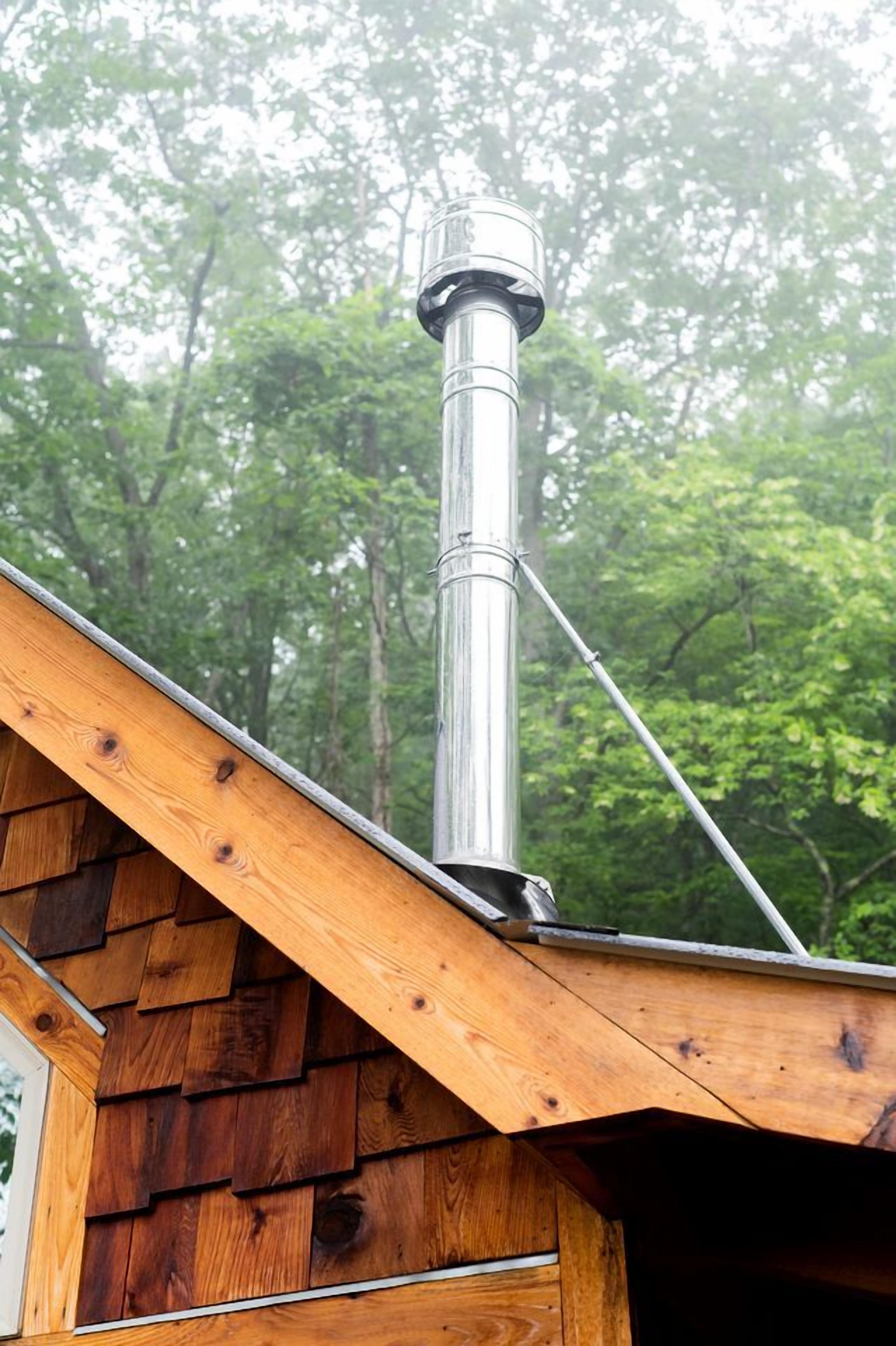 Una cabaña de madera con una chimenea de metal que sobresale del techo.
