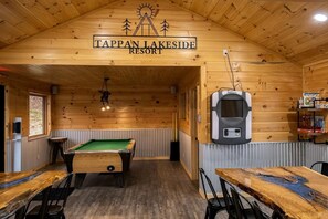 A billiards table, a pool table, and a sign reading 'Tappan Lakeside Resort' in a wooden room.
