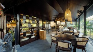 A restaurant with a modern interior, wooden furniture, and a variety of decorative items on display. - Alpha Wolf Lodge (Tabanan)