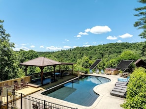 A swimming pool with lounge chairs and a gazebo.