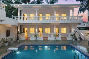 A two-story building with a swimming pool, balconies, and potted plants. - 8fold by LaRiSa Siolim (Siolim)