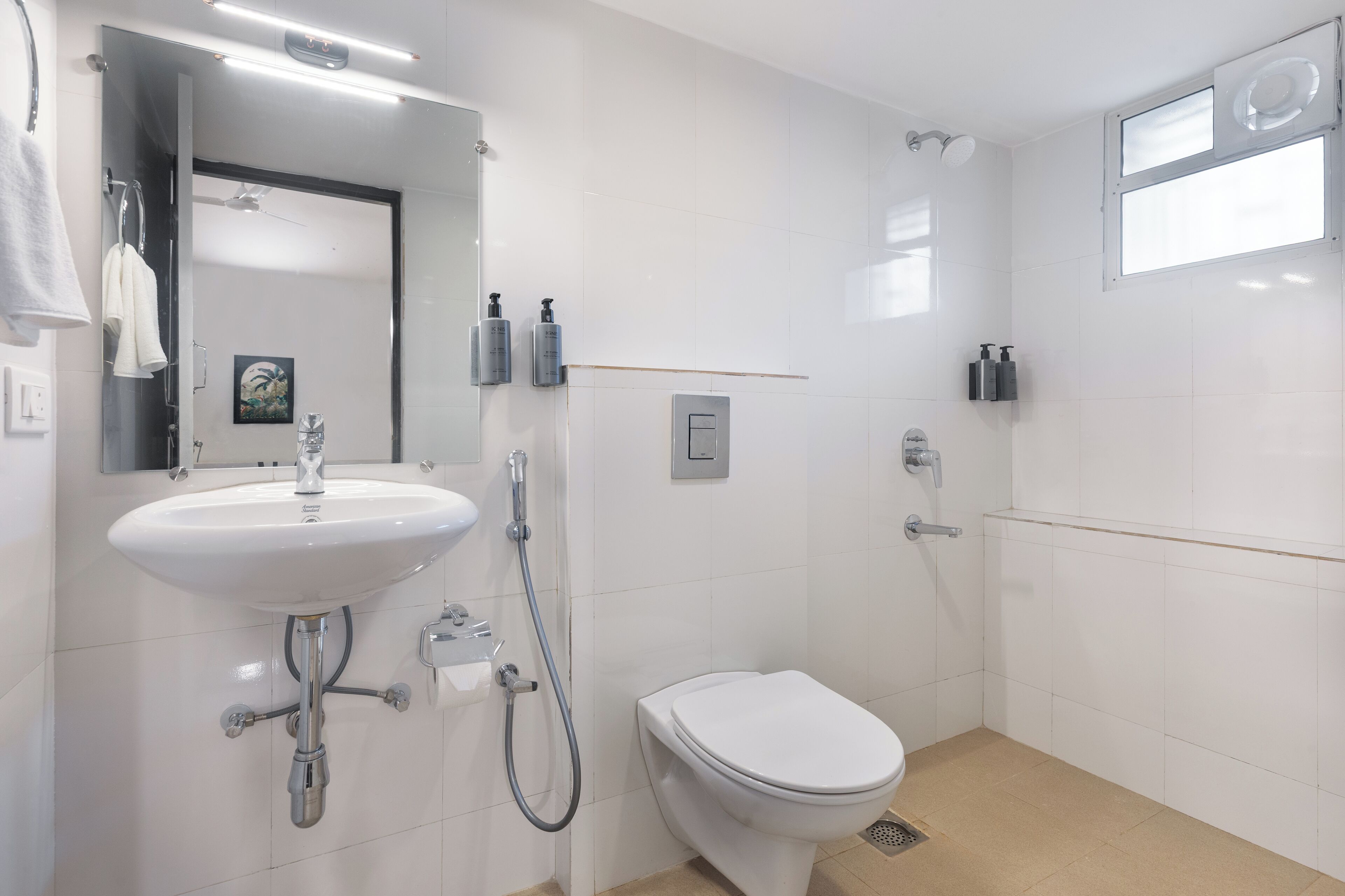 A modern bathroom with a white sink, toilet, and shower.
