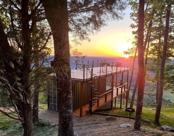 A wooden deck with a staircase leading to a platform overlooking a body of water.