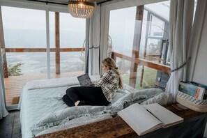 Una habitación con una cama grande, una computadora portátil y un libro abierto sobre una mesa de madera.