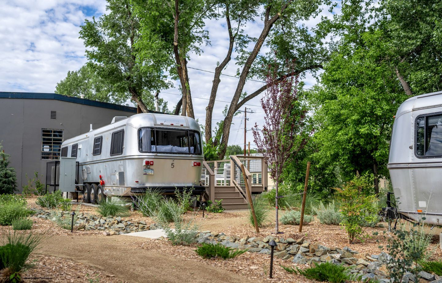 Un véhicule récréatif (VR) est stationné dans un terrain de camping, avec un bâtiment visible à l’arrière-plan.