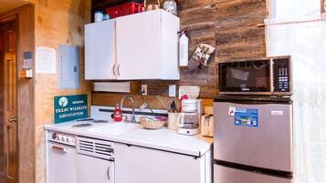 A compact kitchen with a sink, a microwave, a coffee maker, and a refrigerator.