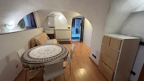 An interior with a round dining table, a sofa, and a built-in cabinet. - Chalet in the Village of Charvensod - Relaxation and Nature (Charvensod)