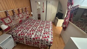A bedroom with a bed, wardrobe, bedside table, and a mirror. - Chalet in the Village of Charvensod - Relaxation and Nature (Charvensod)