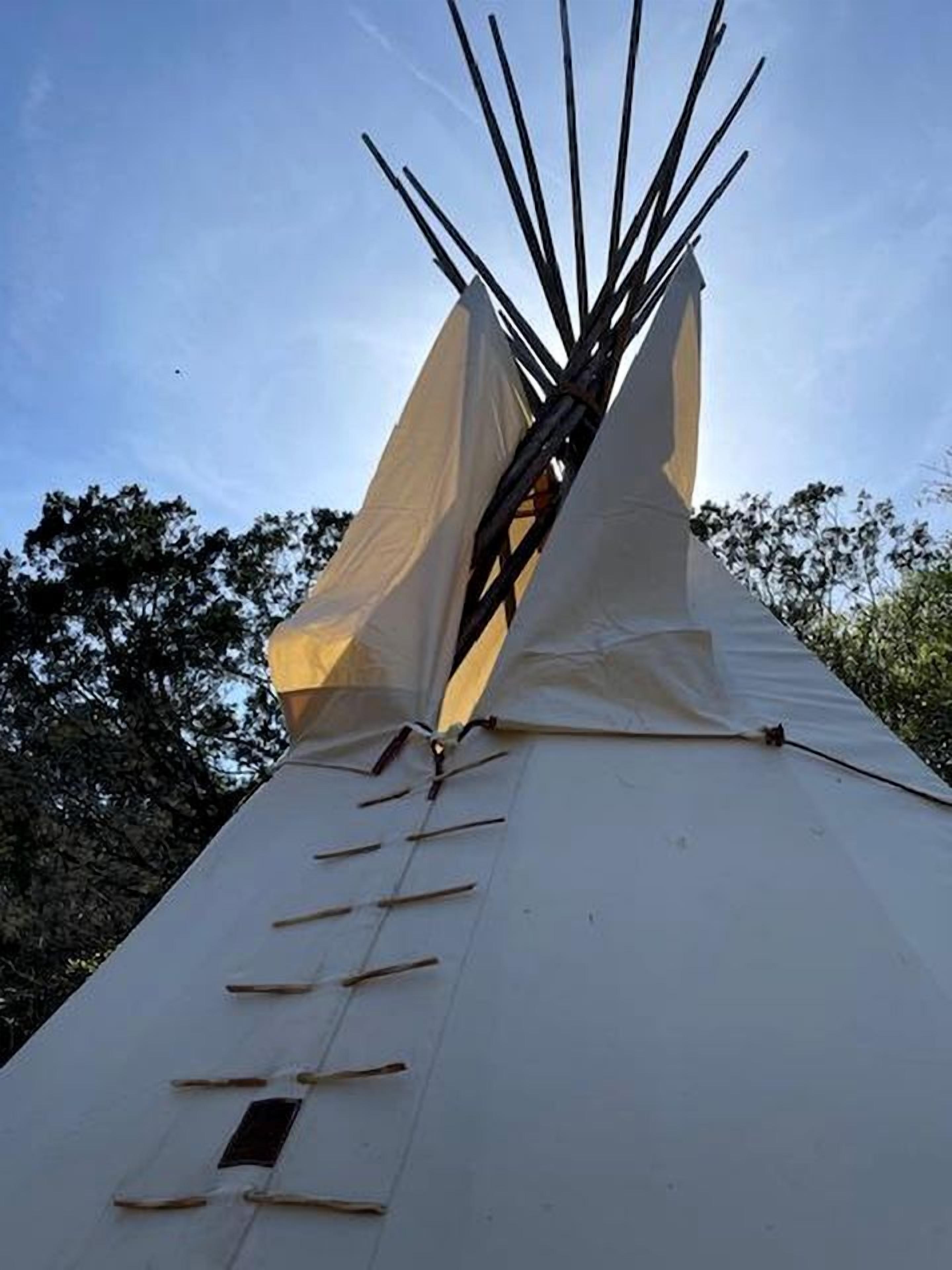 Un tipi con techo cónico y un poste central.