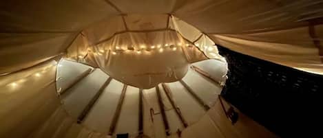 A circular room with a central pole, a hanging object, and a patterned floor.