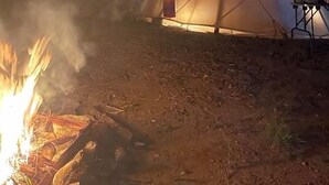 A teepee with a fire in front, surrounded by a dirt ground. - Spacious Tipi with Outdoor BBQ and Fire Pit in Texas (Marble Falls)