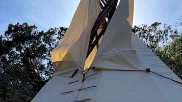 Een tipi met een kegelvormig dak en een centrale paal.