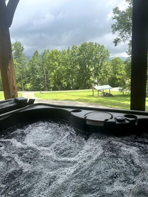 A hot tub with a view of a grassy area and trees. - Appalachian Adventure in this Tiny Cabin near Hiawassee, Ideal for Couples' Glamping (Hayesville)