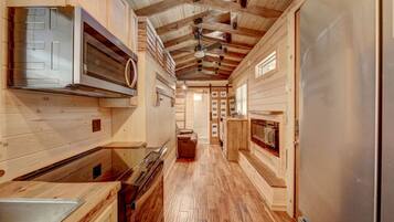A wooden interior with a kitchen area, including a stove, oven, and refrigerator.