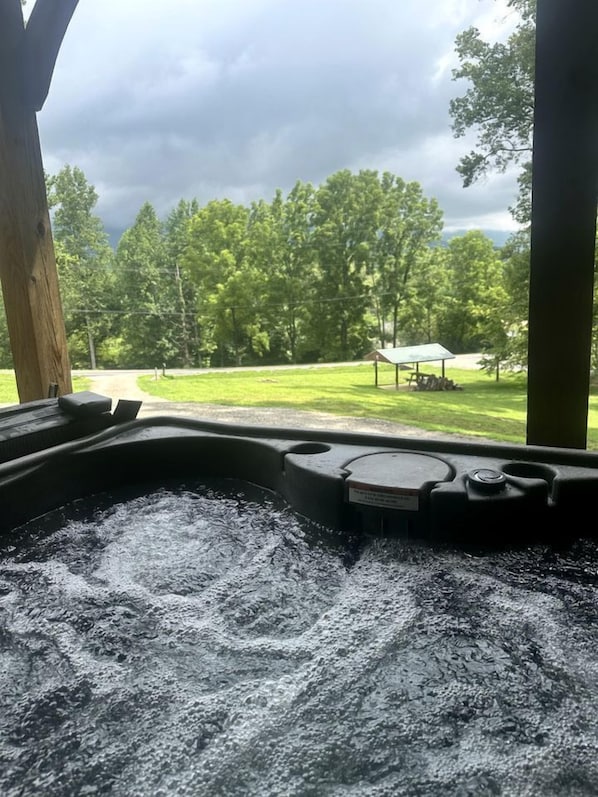 Un jacuzzi con vista a un área verde y árboles.