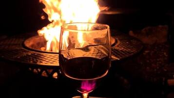 Un verre de vin rouge, avec une flamme en arrière-plan.