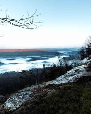 A mountainous landscape with a view of a valley and a body of water.