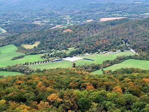 A landscape view with a golf course, trees, and a distant building.