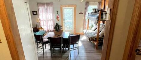 Un interior de madera con comedor, sofá y ventana.