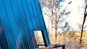 Una terrazza in legno con una vasca idromassaggio e una sedia di legno.