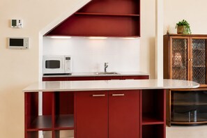 A kitchen with a microwave, a sink, and a cabinet with glass doors. - The View | Panoramic River Views | Sleeps 12 (Sandy Bay)