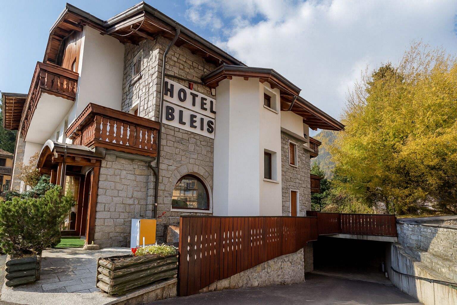 A hotel with a stone facade, a wooden balcony, and a sign reading "HOTEL BLEIS".