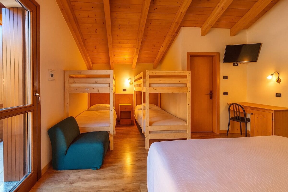 A cozy room with bunk beds, a desk, and a TV.
