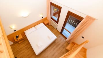 Una camera da letto con un letto, un comodino e una finestra con tende.