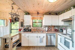 A modern kitchen with white cabinets, a stainless steel sink, and a built-in oven.