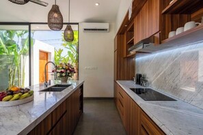 Une cuisine moderne avec des meubles en bois, un plan de travail en marbre et un évier encastré.