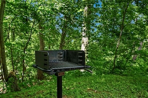 A portable grill in a forested area. - Charming Cabin with Spa and Mountain Views in Sevierville, Tennessee (Sevierville)