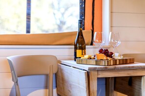 Una mesa de comedor con vino, queso y uvas.