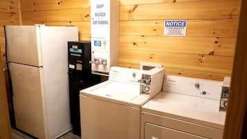 Une buanderie équipée d’un réfrigérateur, d’un distributeur d’eau et d’un lave-linge.