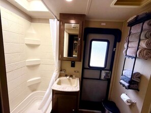 Ein kleines Badezimmer mit Toilette, Waschbecken und einem kleinen Fenster.