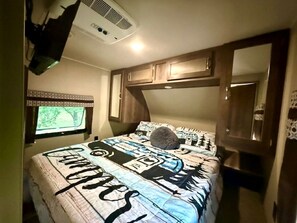 A bedroom with a bed, a window, a ceiling fan, and a door. - Texas Hill Country Glamping Caravan for a Nature Escape near Hamilton Creek (Marble Falls)