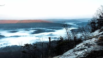 A mountainous landscape with a view of a valley and a body of water.
