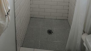 A shower with white subway tiles, a black and white patterned floor, and a small window at the top. - Unique Container with BBQ Ideal for Couples in Georgia (Rising Fawn)