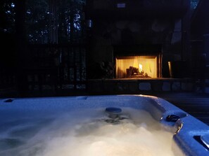 A hot tub with a fire feature in the background.