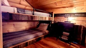 Un intérieur en bois avec des lits superposés et une petite table.
