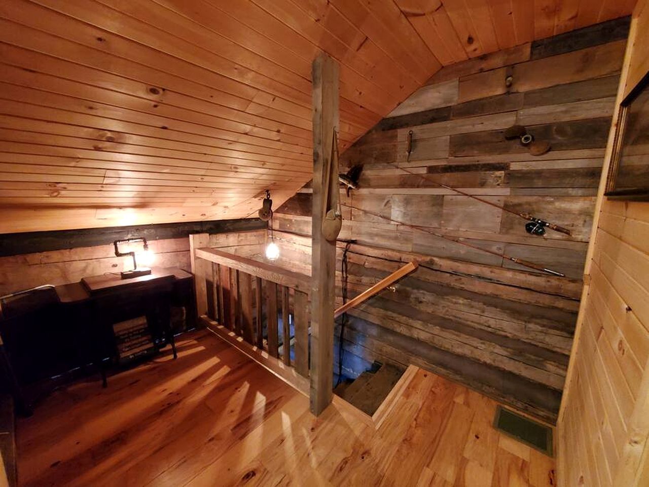 A wooden interior with a staircase, a desk, and a chair.