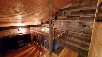 A wooden interior with a staircase, a desk, and a chair.