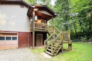 A two-story building with a wooden deck and stairs leading to a balcony.